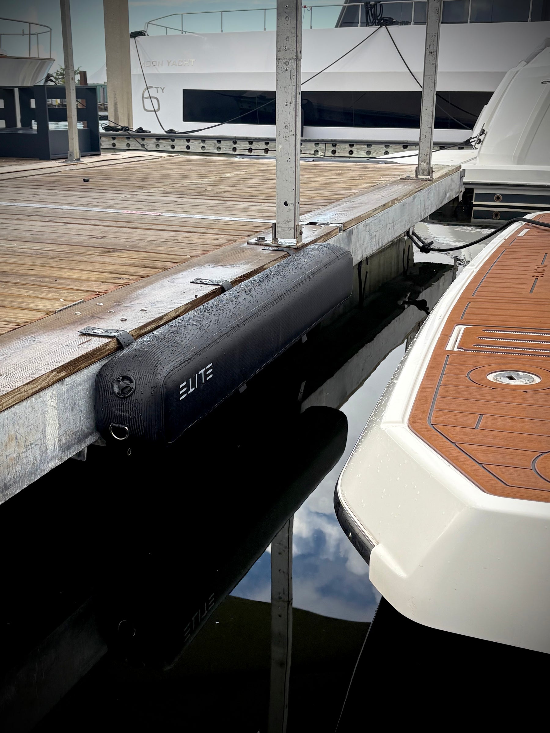 An ELITE RAIL X-6 mounted along a wooden dock beside a yacht swim platform.