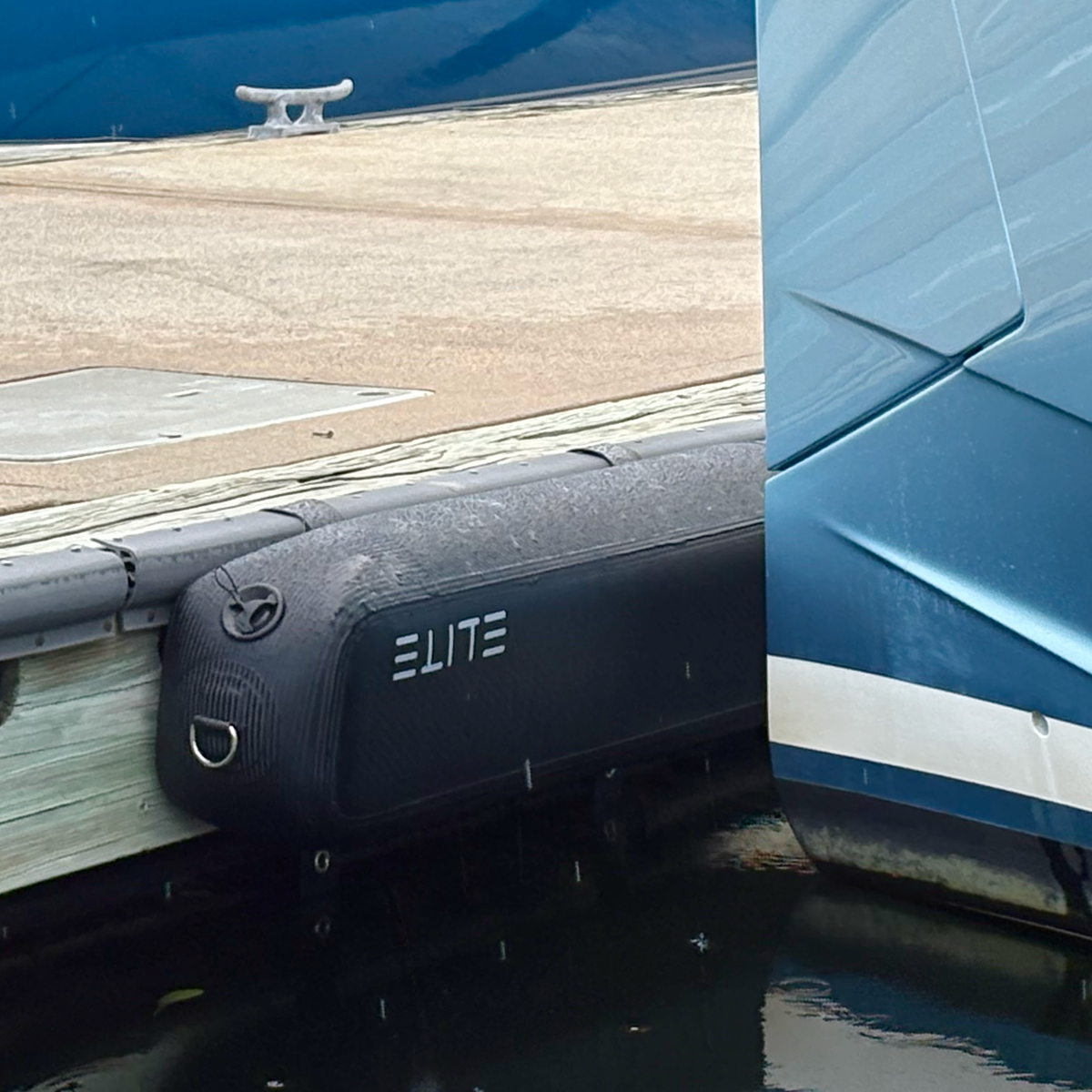ELITE RAIL X-4 mounted on a dock beside the blue hull of a boat.