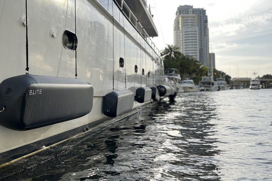 An ELITE WALL X-8 and other ELITE fenders protecting the side of a large yacht at a marina.