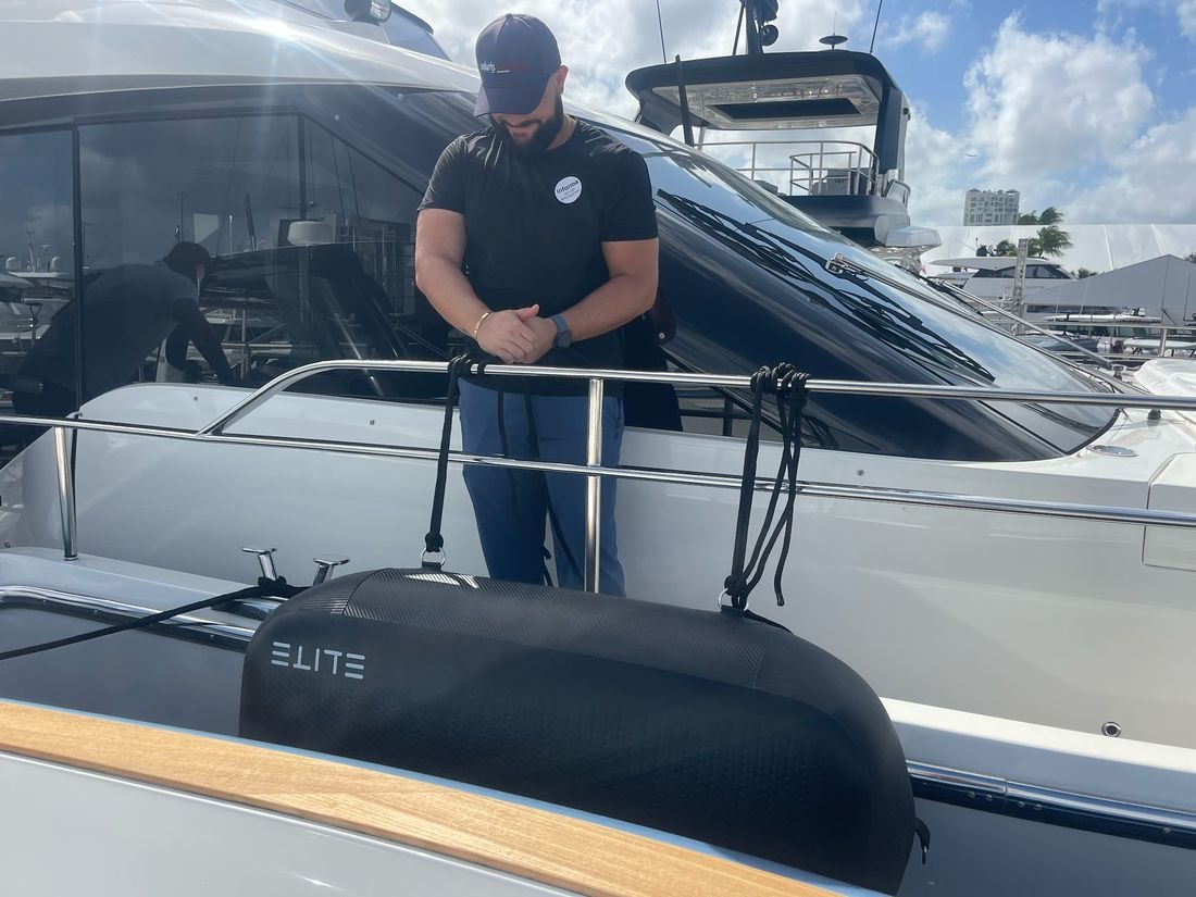 A crew member holding the lines of an ELITE WALL X-4 between two yachts.