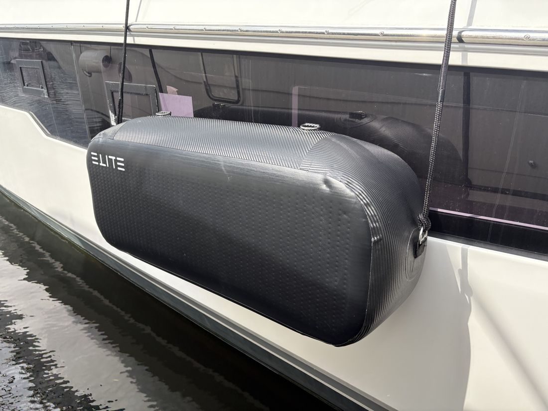 An ELITE WALL X-4 suspended horizontally beside a yacht at the marina.